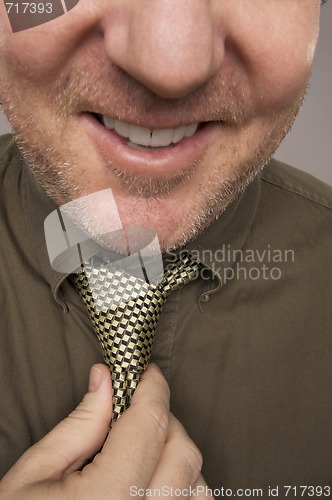 Image of Smiling Man Fixing Tie