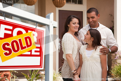 Image of Hispanic Family in Front of Their New Home with Sold Sign
