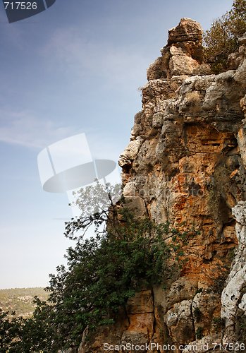 Image of Steep weathered cliff face over dark sky