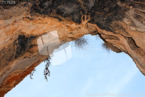 Image of Stone arch of the cave exit on sky background 