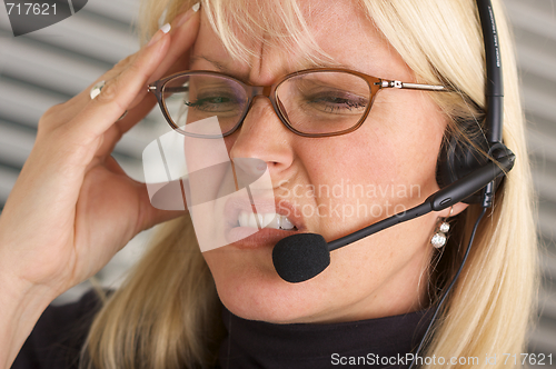 Image of Businesswoman with Phone Headset and Headache