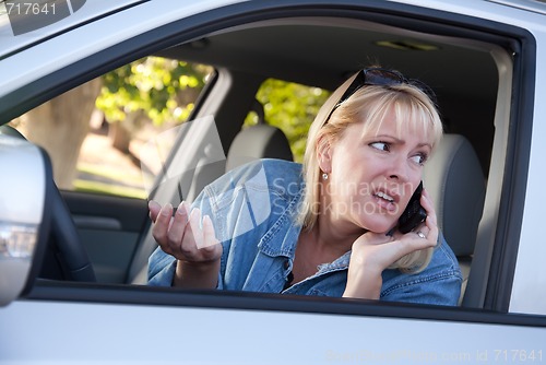 Image of Concerned Woman Using Cell Phone While Driving