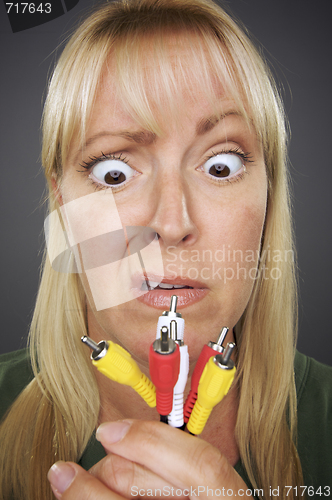Image of Confused Woman Holding Electronic Cables
