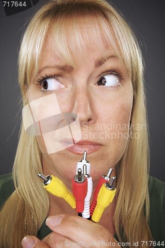 Image of Confused Woman Holding Electronic Cables