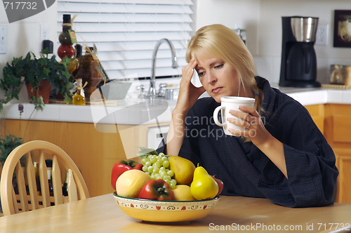 Image of Woman Holding Head in Kitchen