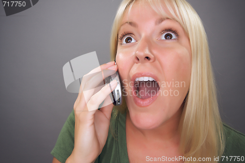 Image of Stunned Blond Woman Using Cell Phone 