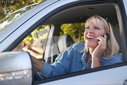 Image of Attractive Woman Using Cell Phone While Driving