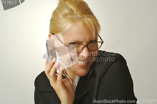 Image of Elated Businesswoman Smiles While Using Her Cell Phone