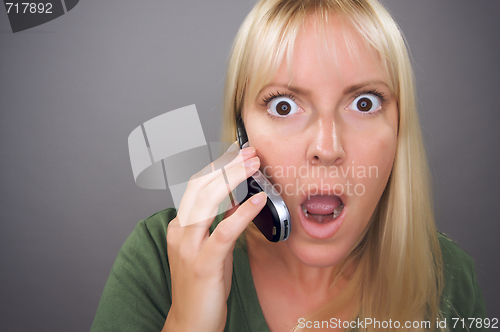 Image of Stunned Blond Woman Using Cell Phone