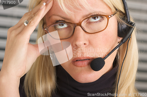 Image of Businesswoman with Phone Headset and Headache