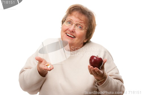 Image of Confused Senior Woman Holding Apple and Vitamins