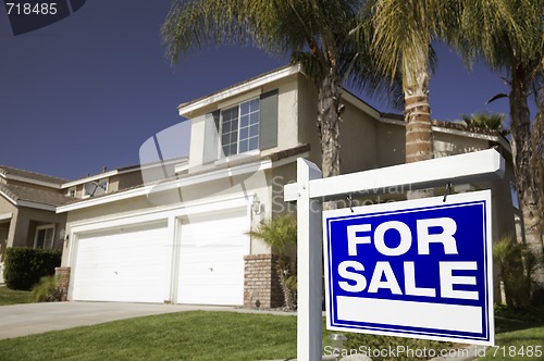 Image of Blue For Sale Real Estate Sign and House