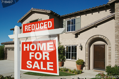 Image of Reduced Home For Sale Sign & New House