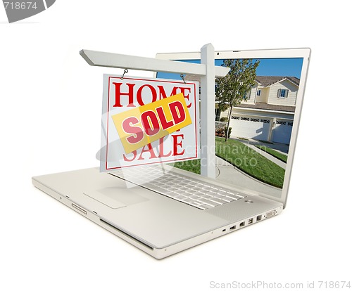 Image of Sold Home for Sale Sign & New House on Laptop