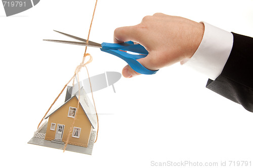 Image of Hand with Scissors Cutting String Holding House 