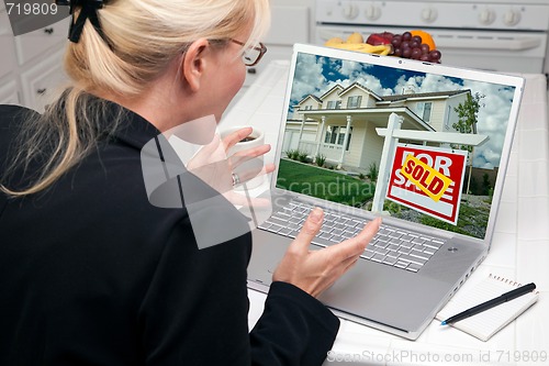 Image of Excited Woman In Kitchen Using Laptop - Real Estate Success