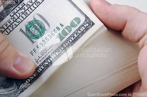 Image of Man Fanning Large Stack of One Hundred Dollar Dollar Bills