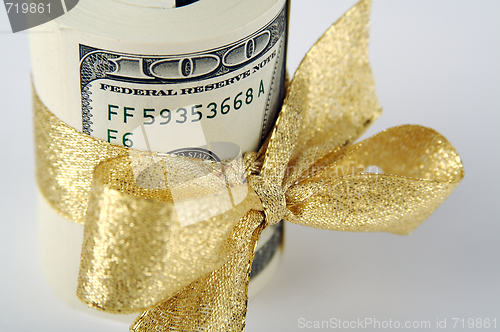 Image of One Hundred Dollar Bills Wrapped in Gold Ribbon.