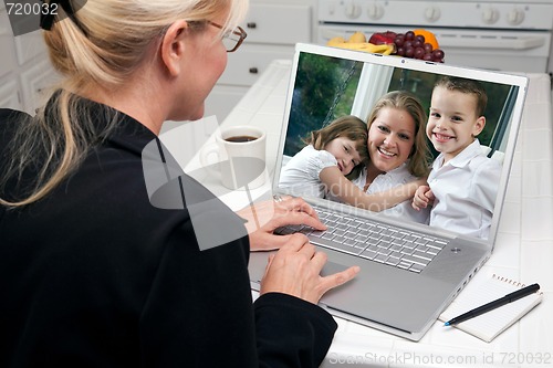 Image of Woman In Kitchen Using Laptop - Family and Friends