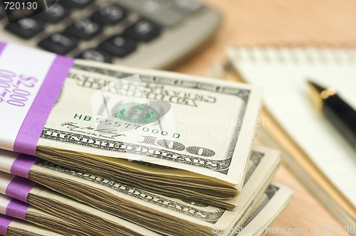 Image of Stack of Money, Calculator, Paper and Pen