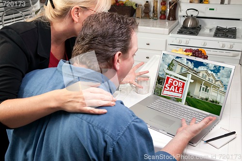 Image of Couple In Kitchen Using Laptop - Real Estate