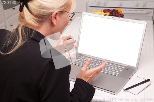 Image of Excited Woman In Kitchen Using Laptop with Blank Screen