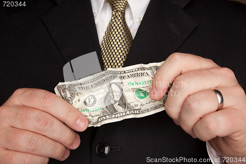 Image of Businessman Holding Wrinkled Dollar Bill