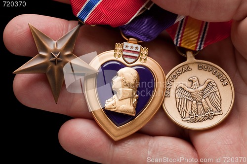 Image of Man Holding Purple Heart, Bronze and National Defense War Medals