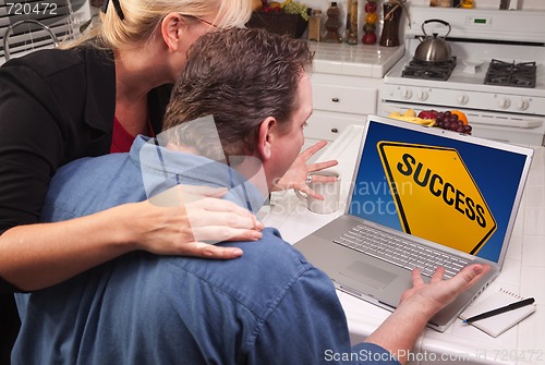 Image of Couple In Kitchen Using Laptop - Success Sign
