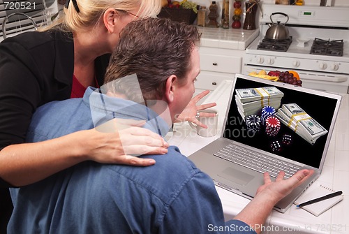 Image of Couple In Kitchen Using Laptop - Online Poker