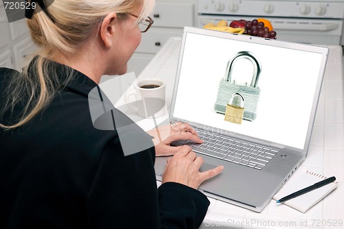 Image of Woman In Kitchen Using Laptop - Security