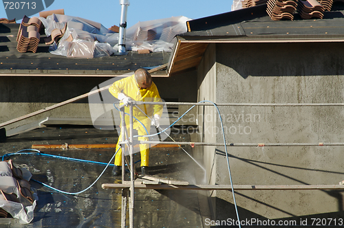 Image of Construction Worker Pressure Washes 