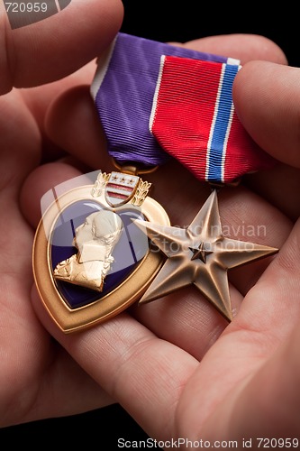 Image of Man Holding Purple Heart and Bronze War Medals