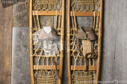 Image of Antique Snowshoes on Rustic Cabin Wall