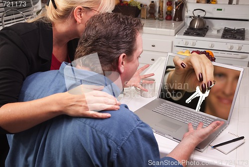 Image of Couple In Kitchen Using Laptop - House Keys