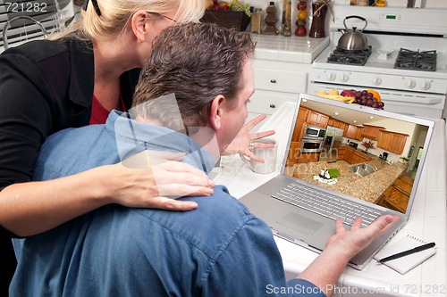 Image of Couple In Kitchen Using Laptop - Home Improvement