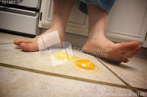 Image of Eggs on the Floor at Man's Feet