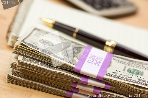 Image of Stack of Money, Calculator, Paper and Pen