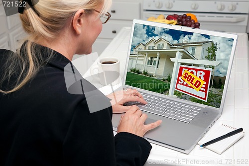 Image of Woman In Kitchen Using Laptop for Real Estate