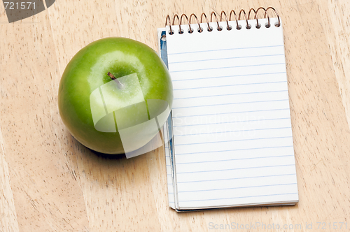 Image of Pad of Paper and Apple on Wood