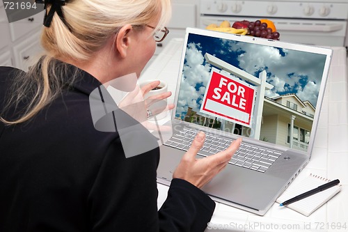 Image of Excited Woman In Kitchen Using Laptop  - Real Estate Shopping