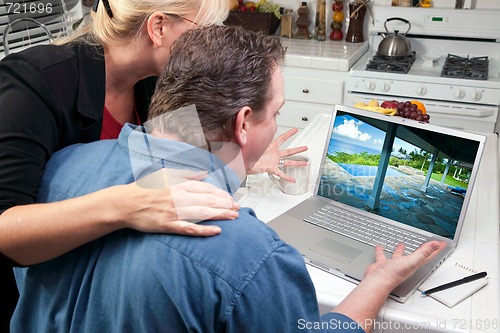 Image of Couple In Kitchen Using Laptop - Real Estate and Vacations