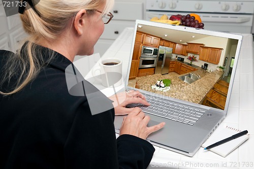 Image of Woman In Kitchen Using Laptop - Home Improvement