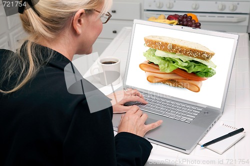 Image of Woman In Kitchen Using Laptop - Food and Recipes