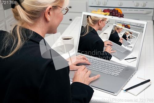 Image of Abstract of Woman In Kitchen Using Laptop