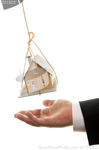 Image of Businessman's Hand Under Dangling House