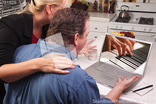 Image of Couple In Kitchen Using Laptop - Music Performance