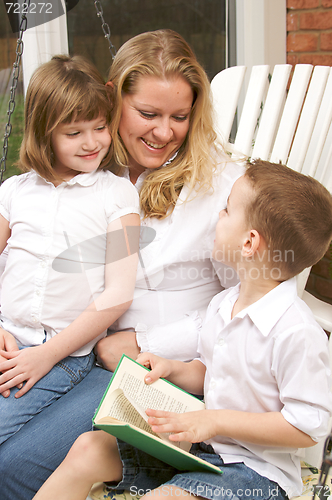Image of Young Boy Reads to His Mother and Sister