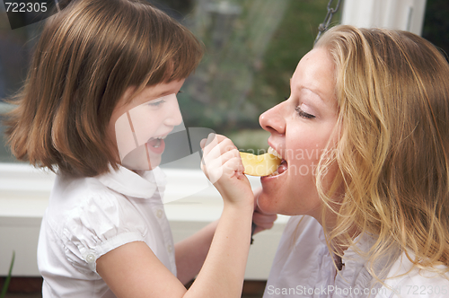 Image of Daughter Feeding Mom an Apple