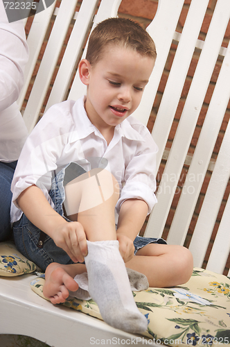 Image of Adorable Young Boy Getting Socks On